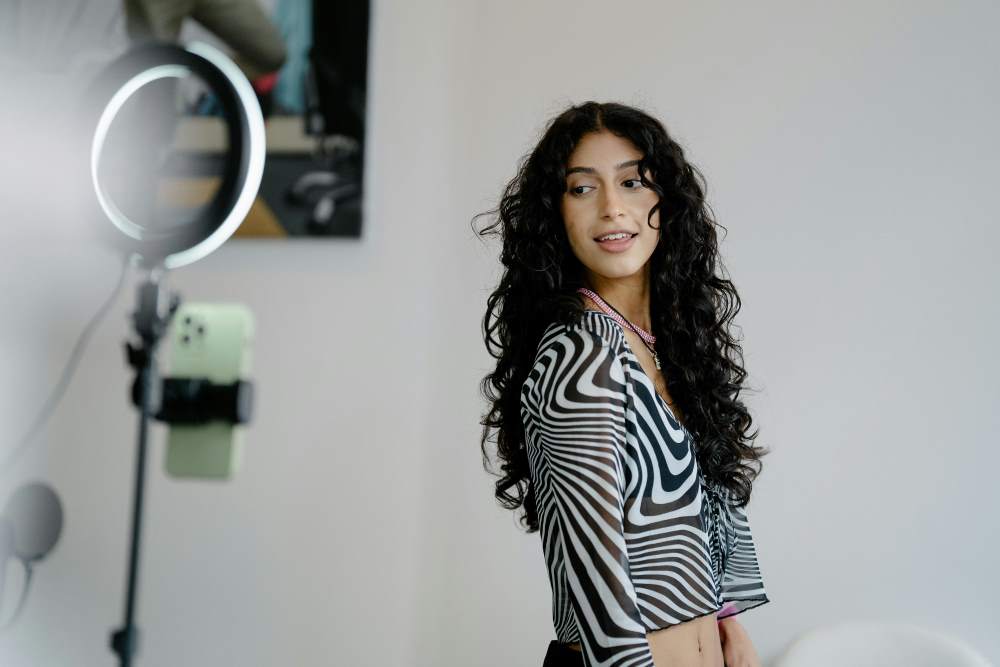 Woman standing in front of a phone and ring light
